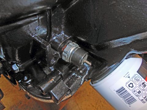 1990 Ford Bronco - Close-up view of an engine component, likely a sensor, next to an oil filter.