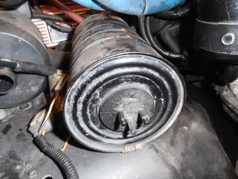 1990 Ford Bronco - Close-up of an emissions canister, a component of a vehicle's exhaust system.