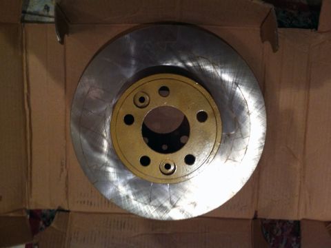 2001 Mercury Grand Marquis - New brake rotor with gold-painted hub, ready for installation.