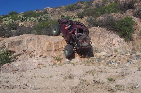 1981 Ford F-150 - Custom off-road truck navigating a challenging rocky terrain on a sunny day.