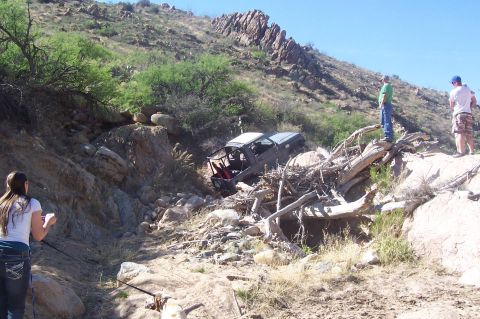 1981 Ford F-150 - A truck is stuck in a ravine with people observing the situation.