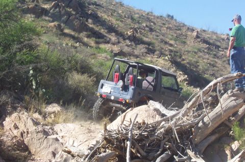 1981 Ford F-150 - An off-road vehicle tackles a challenging rocky terrain on a sunny day.