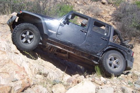 1981 Ford F-150 - A black Jeep Wrangler navigates a challenging rocky trail, its off-road capabilities.