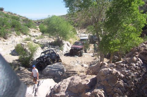 1981 Ford F-150 - Off-road vehicles traverse a challenging rocky terrain in a desert canyon.
