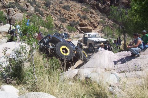 1981 Ford F-150 - Two off-road vehicles navigate a challenging rocky landscape with onlookers present.