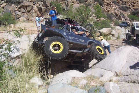 1981 Ford F-150 - A group of people watch as a modified off-road truck navigates a challenging rocky obstacle course.