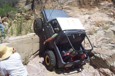 1981 Ford F-150 - An off-road vehicle navigates a challenging rocky terrain with onlookers observing the difficult maneuver.