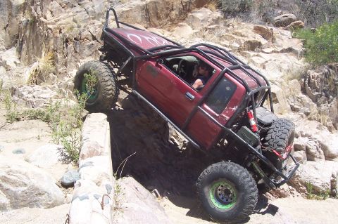 1981 Ford F-150 - This heavily modified pickup truck is navigating a challenging off-road obstacle course.