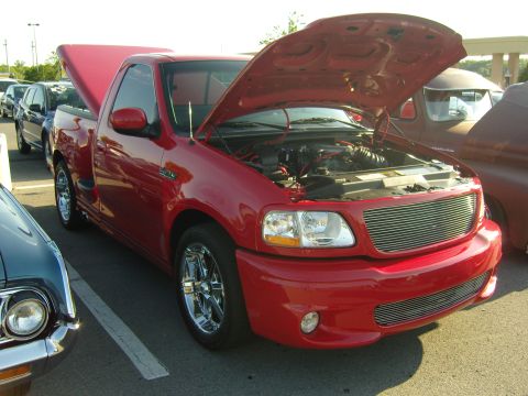 2007 Ford Mustang - A red pickup truck is parked with its hood open, revealing the engine compartment.