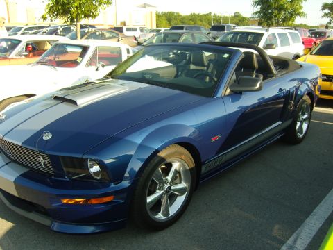 2007 Ford Mustang - A blue 2007 Ford Mustang Shelby GT convertible is parked in a lot with other vehicles.