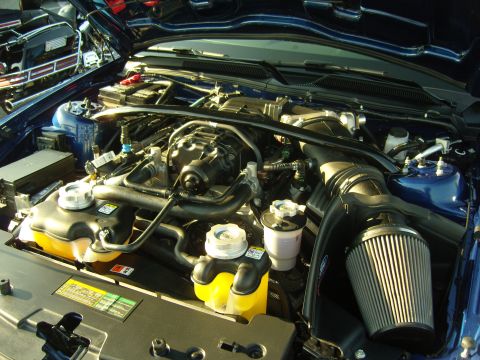 2007 Ford Mustang - Close-up of a car's engine bay, showing the air intake and fluid tanks.