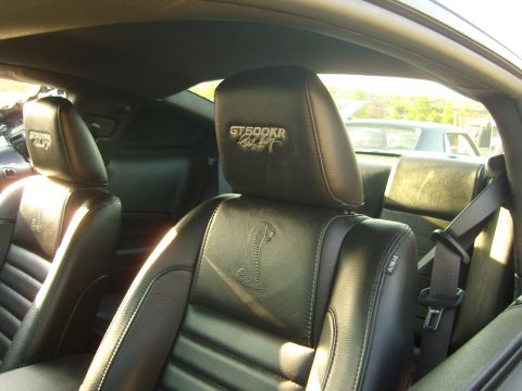 2007 Ford Mustang - The interior of a Ford Mustang features black leather seats with distinctive GT500KR badging on the headrests.