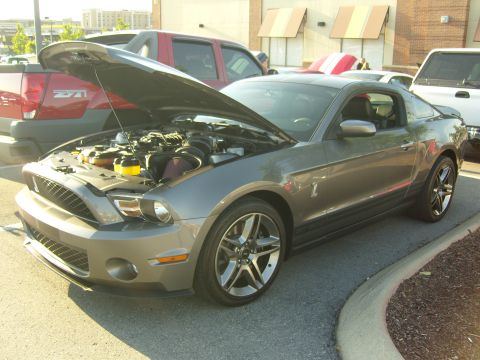 2007 Ford Mustang - A gray 2007 Ford Mustang is parked with its hood open, revealing the engine compartment.