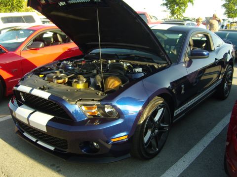 2007 Ford Mustang - A blue Ford Mustang Shelby GT500 is parked with its hood open, revealing the engine bay.