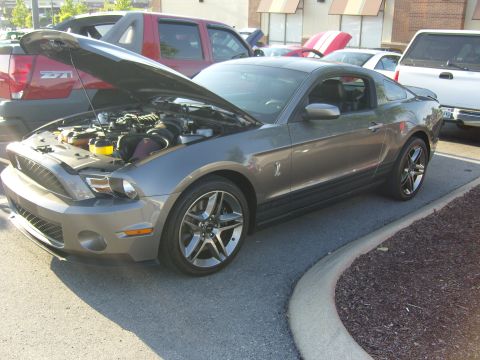 2007 Ford Mustang - A gray 2007 Ford Mustang is parked with its hood up, revealing the engine compartment.