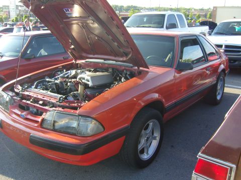 2007 Ford Mustang - Orange fox body Ford Mustang with hood open at a car meet.