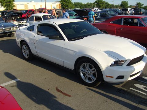 2007 Ford Mustang - A white 2010 Ford Mustang is parked at an outdoor event with other cars around it.