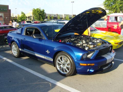 2007 Ford Mustang - A blue 2007 Ford Mustang GT500KR is parked with its hood open at a car show.