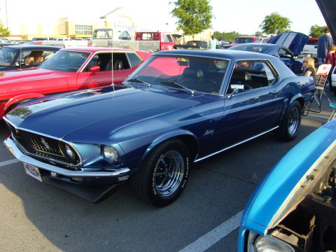 2007 Ford Mustang - A classic blue Ford Mustang is parked at an outdoor event with other vehicles visible.