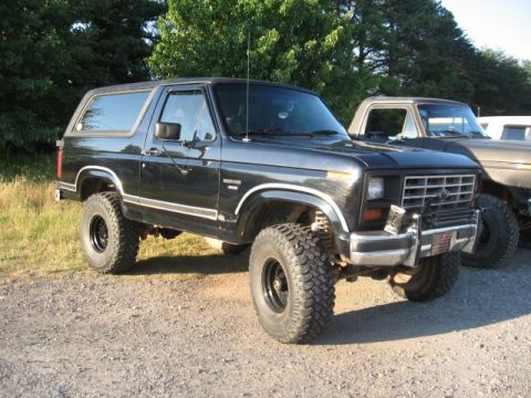 1978 Ford Bronco - Black 1978 Ford Bronco with lifted suspension parked outdoors next to another vehicle.