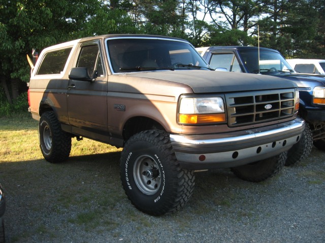 Brown 1992 Ford Bronco with lifted suspension and off-road tires parked outdoors
