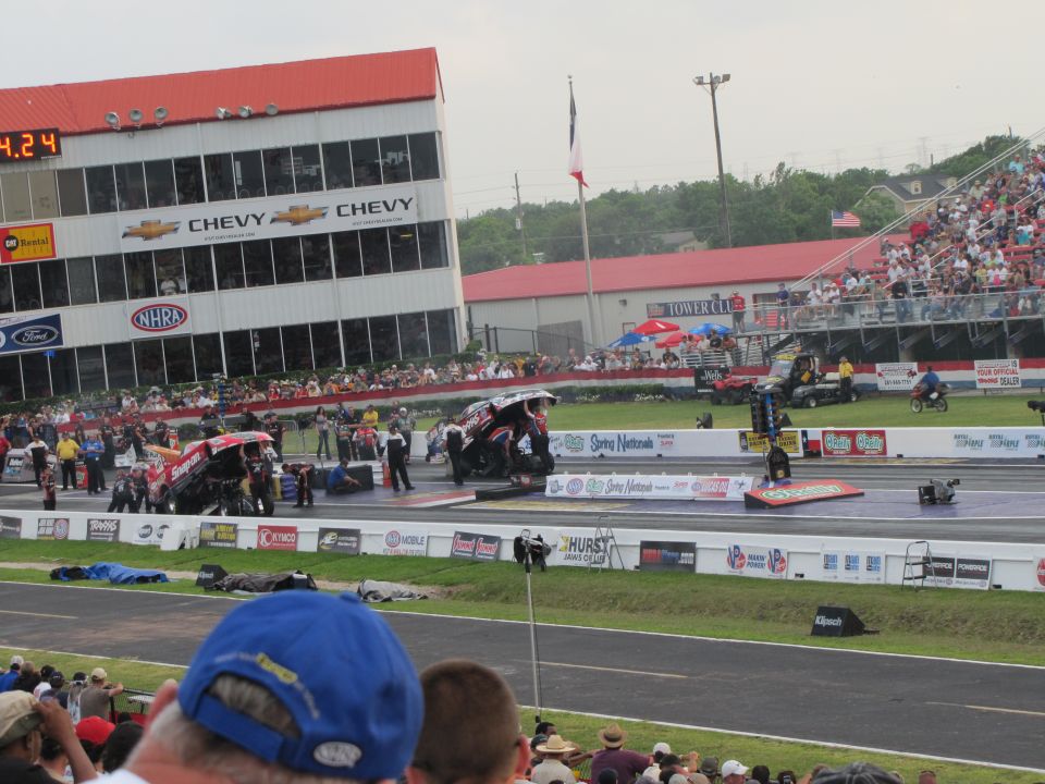 Drag racing scene with dragsters on track, grandstands full of spectators