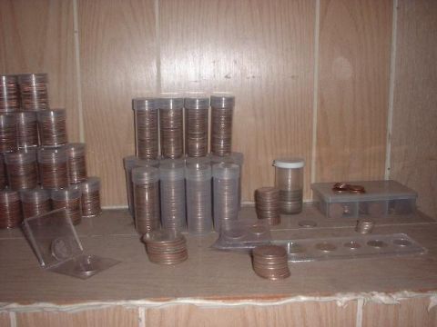 1993 Ford Bronco - Many rolls of coins are organized on a shelf, some in plastic tubes and others in coin holders.