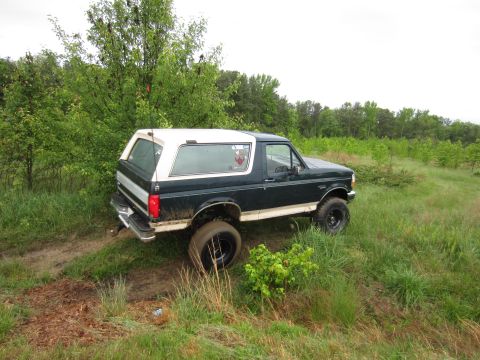 1992 Ford Bronco - This 1992 Ford Bronco is seen off-roading in a grassy, wooded area.