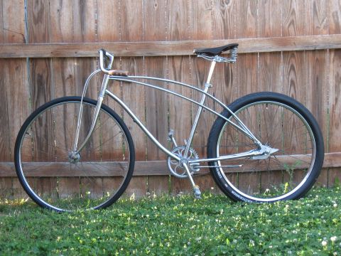 1994 Ford Bronco - A custom cruiser bicycle with a chrome frame and black tires is displayed against a wooden fence.