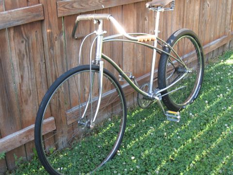 1994 Ford Bronco - A vintage cruiser bicycle rests against a wooden fence on a sunny day.