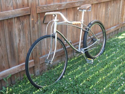 1994 Ford Bronco - A vintage bicycle with chrome accents rests against a weathered wooden fence, bathed in sunlight.