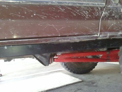 1982 Ford Bronco - Close-up of a vehicle's undercarriage, highlighting custom red suspension components.