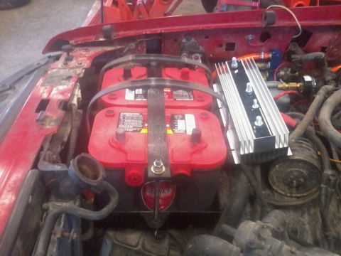 1995 Ford F-150 - Close-up of a dual battery setup with an isolator in a red vehicle's engine compartment.