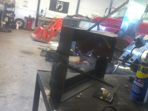 1995 Ford F-150 - A dual battery tray with an isolator is shown on a workbench in a garage setting.