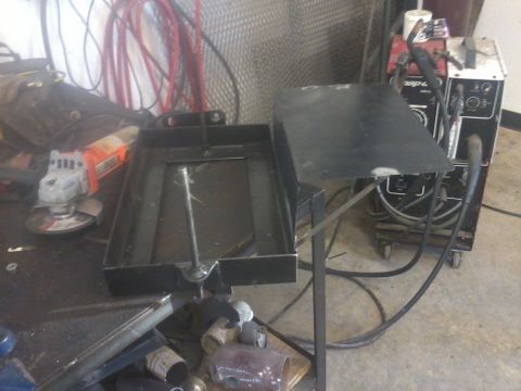 1995 Ford F-150 - Welding equipment and a metal tray are on a workbench next to an angle grinder.