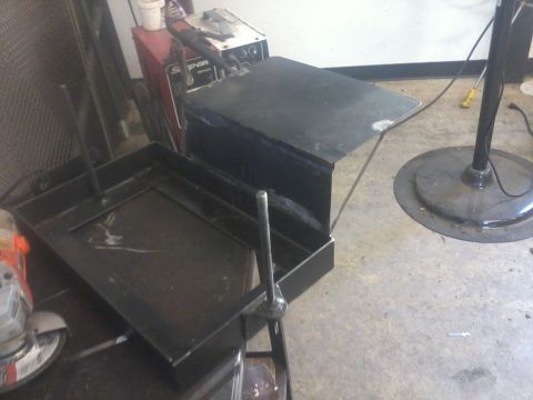 1995 Ford F-150 - A dual battery tray and isolator are shown in a workshop setting with tools and equipment.