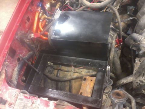 1995 Ford F-150 - Close-up view of a dual battery tray with an isolator installed in the engine compartment.