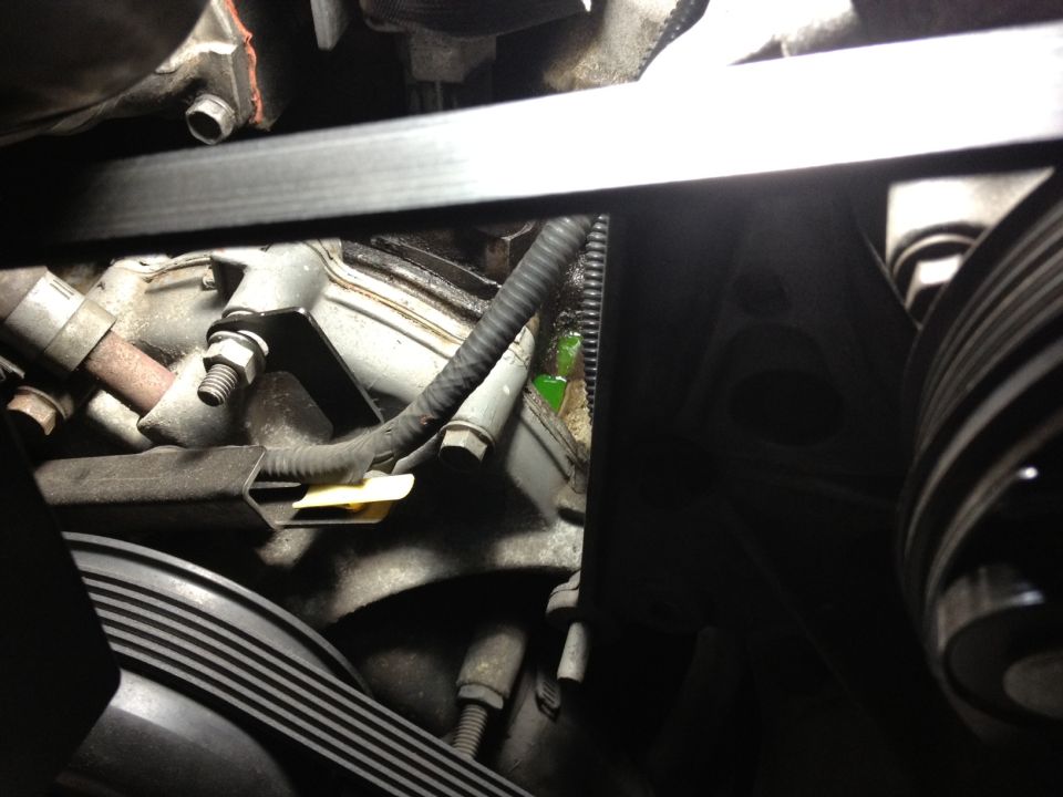 Engine coolant leak visible near belt pulley and hoses
