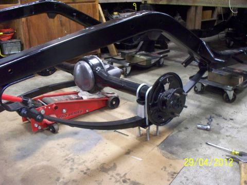 1990 Ford Bronco - A vehicle's frame and rear axle assembly are being worked on in a garage setting.