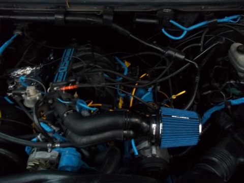 1989 Ford Bronco - Aftermarket cold air intake installed on an engine, blue accents and "5.0" branding.