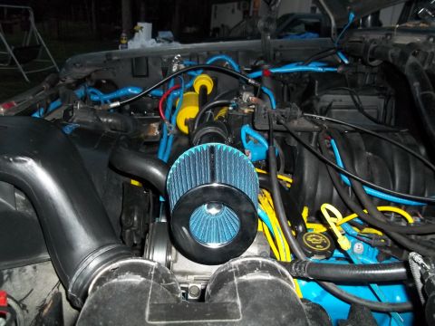 1989 Ford Bronco - Custom engine bay modifications a blue cone air filter and vibrant blue and yellow wiring accents.