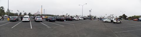 2003 Ford Crown Victoria - Panoramic view of a show lot full of sedans with amusement park coasters on the horizon.