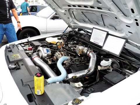 2003 Ford Crown Victoria - Turbocharged Ford engine with blue and silver charge piping and info cards mounted under the hood.
