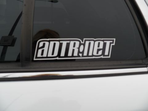 2003 Ford Crown Victoria - Close-up of an ADTR.net sticker applied to the rear side glass of a white vehicle.
