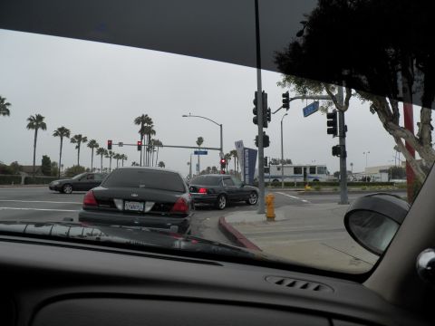 2003 Ford Crown Victoria - Dashboard-view of dark sedans stopped at a signalized intersection, fire hydrant and bus beyond