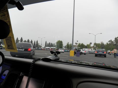 2003 Ford Crown Victoria - Interior dash view showing dark sedan ahead and rows of show cars across a wide lot