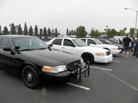 2003 Ford Crown Victoria - Front three-quarter of a black Ford sedan with brush guard; white sedan parked alongside