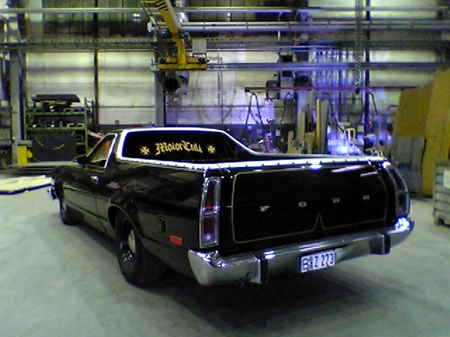 Black Ford Ranchero from rear three-quarter in an industrial shop