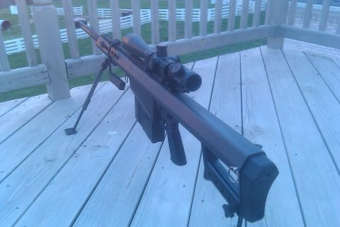2000 Mercury Grand Marquis - A sniper rifle with a scope and bipod is displayed on a weathered wooden deck.