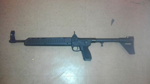 2000 Mercury Grand Marquis - A black semi-automatic rifle is shown lying on a tiled floor.